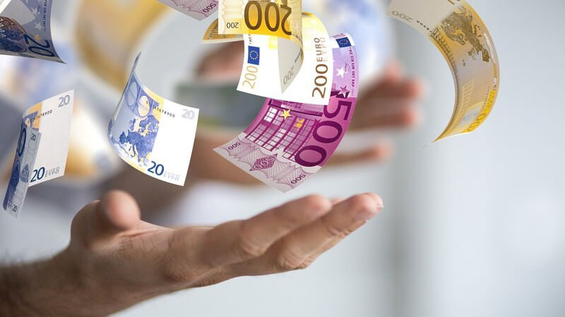 Euro-Geldscheine über offenen Händen - Erfolg und Gewinn im Beruf