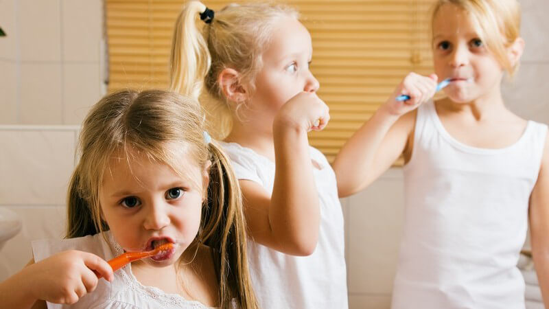 Drei kleine Schwestern im Bad beim Zähneputzen