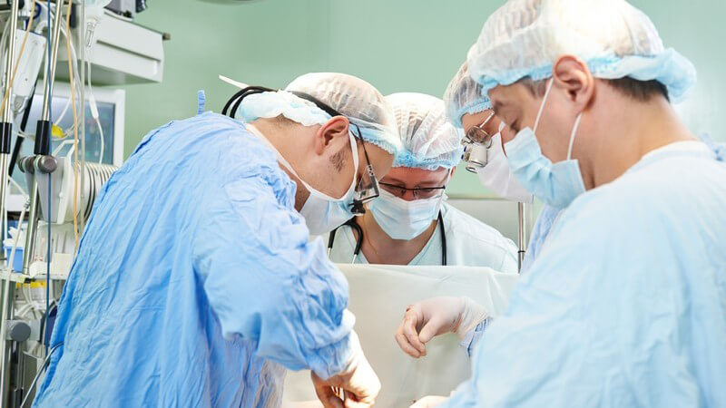 Team aus vier Chirurgen während einer schweren Operation