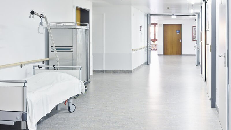 Leerer Flur im Krankenhaus, im Gang steht Krankenbett