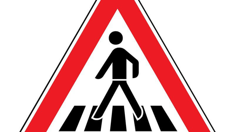Rotes Verkehrsschild warnt vor einem Fußgängerüberweg