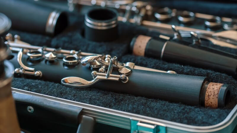 Auseinandergebaute dunkelgraue Klarinette liegt in einem Instrumentenkoffer