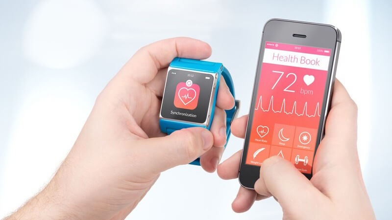 Datenaustausch (Gesundheits-App) zwischen einer blauen Smartwatch und einem schwarzen Smartphone