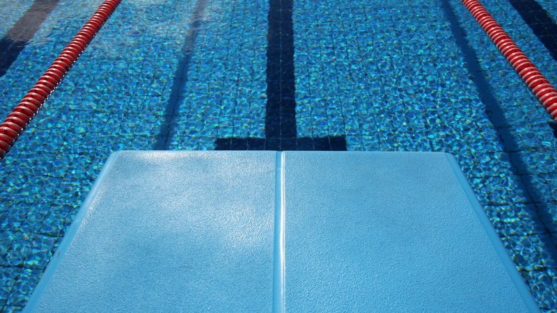 Sprungbrett im Schwimmbad, darunter leeres Becken