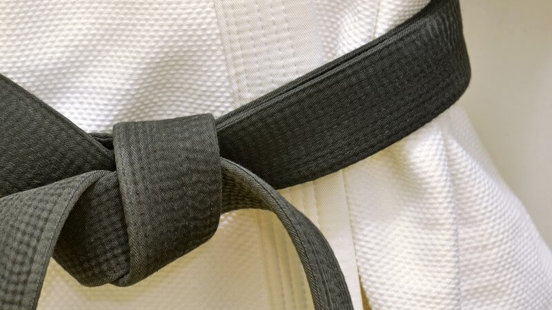 Schwarzer Gürtel auf weißem Karate-Anzug