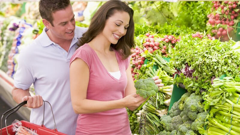 Junges Paar beim Einkaufen im Supermarkt in Gemüseabteilung