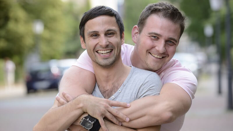 Glückliches Schwulenpaar umklammert auf einer Straße