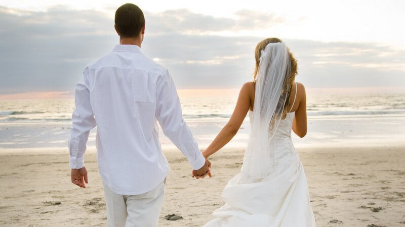 Brautpaar in weiß am Strand