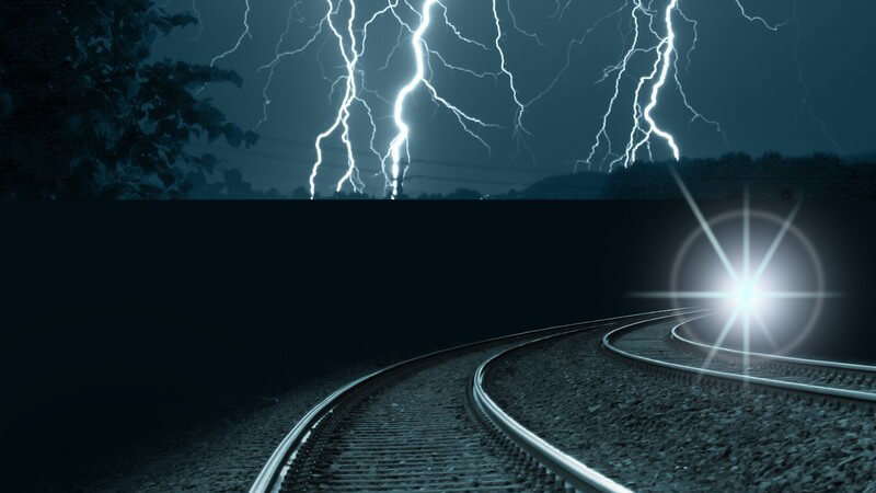 Eisenbahnschienen bei Nacht, Blitze am dunklen Himmel