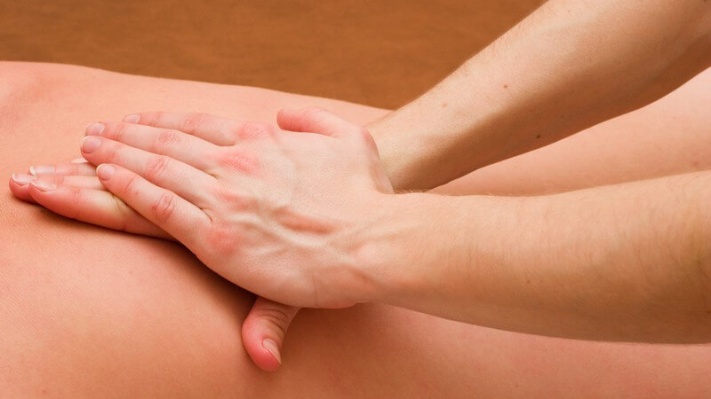 Massage - Rückenmassage mit zwei übereinander liegenden Händen