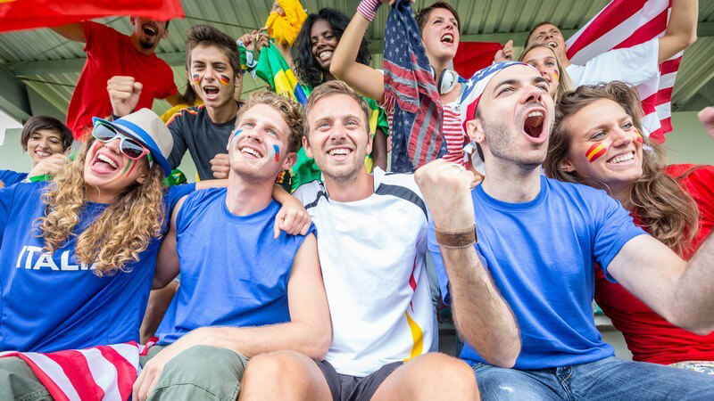 Fans im Fußball-Stadion aus unterschiedlichen Ländern jubeln