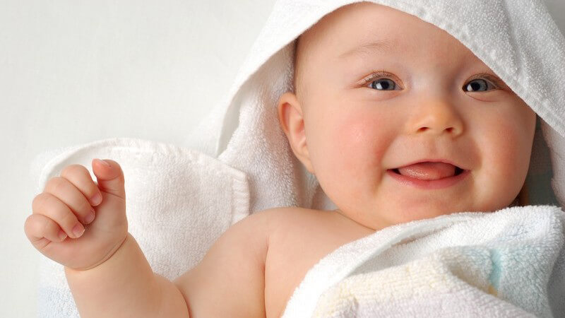 Lächelndes Baby nach Baden in Handtuch eingewickelt