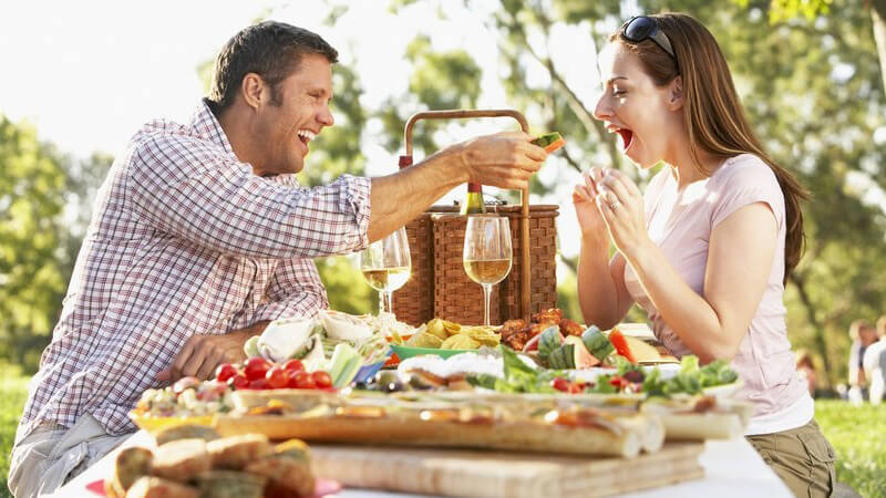 Paar draußen beim Picknick mit Weingläsern