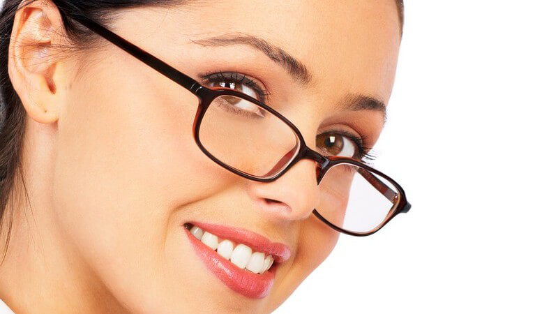 Geschäftsfrau mit dunkelbrauner Brille lächelt in Kamera