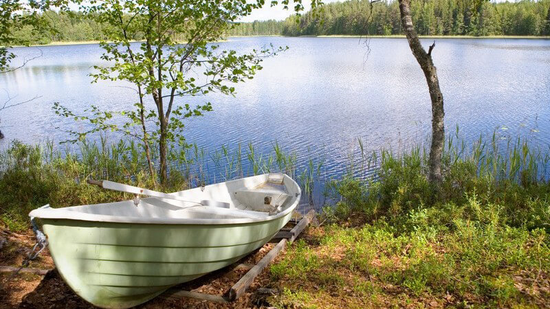 Wald am See, Sonnenlicht, weißes Paddelboot o. Ruderboot an Land, romantische Situation