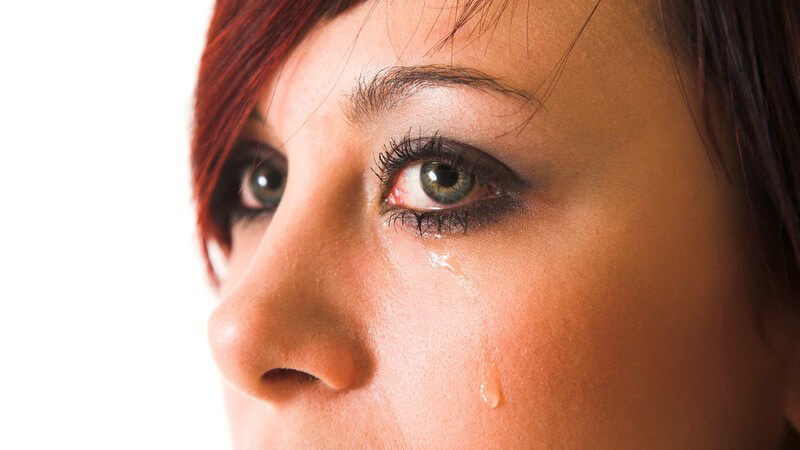Gesicht einer jungen, weinenden Frau, Träne unterm linken Auge