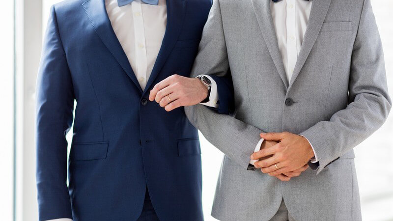 Schwules Paar Arm in Arm im feinen Anzug und Fliege