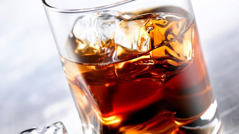 Nahaufnahme Glas mit Whiskey und Eiswürfeln