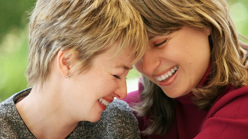 Zwei lachende Frauen nah beieinander