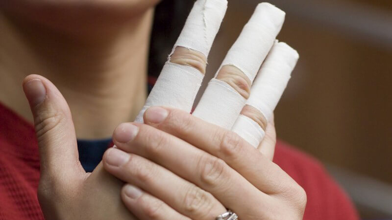 Hand mit drei bandagierten Fingern