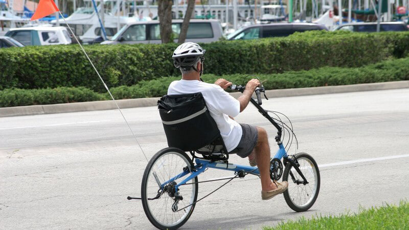 Rentner mit Helm auf Fahrrad in der Stadt