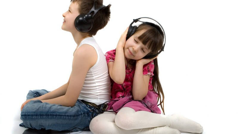 Junge und Mädchen hören Musik über Kopfhörer, weißer Hintergrund