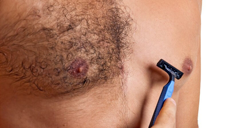 Männlicher Oberkörper, Brust wird mit Nassrasierer rasiert