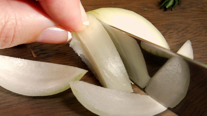 Zwiebel wird auf Brett geschnitten