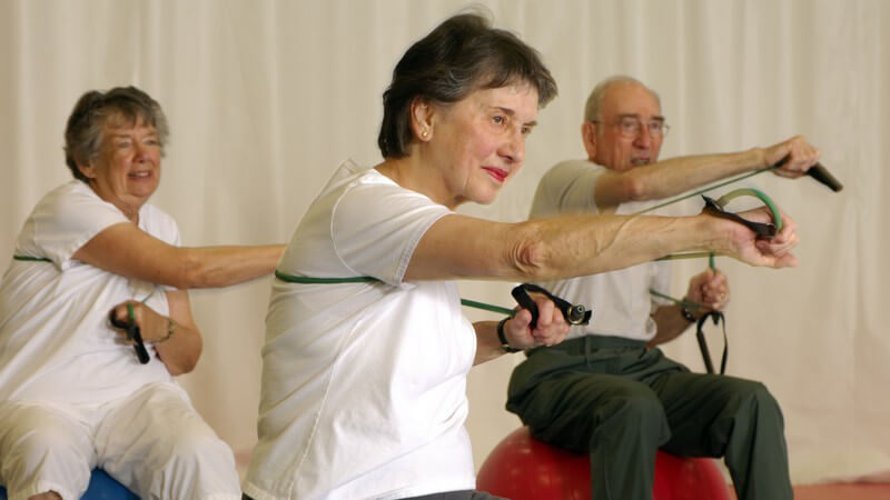 Senioren auf Gymnastikbällen bei Fitnessübungen