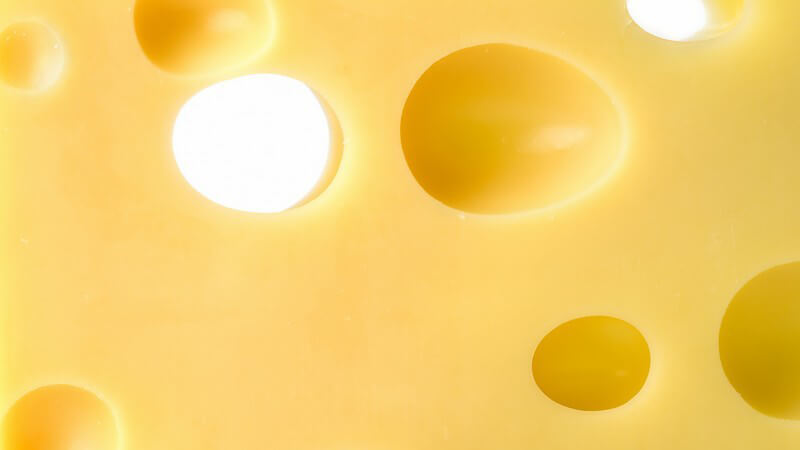 Nahaufnahme gelber Käse mit Löchern, Emmentaler