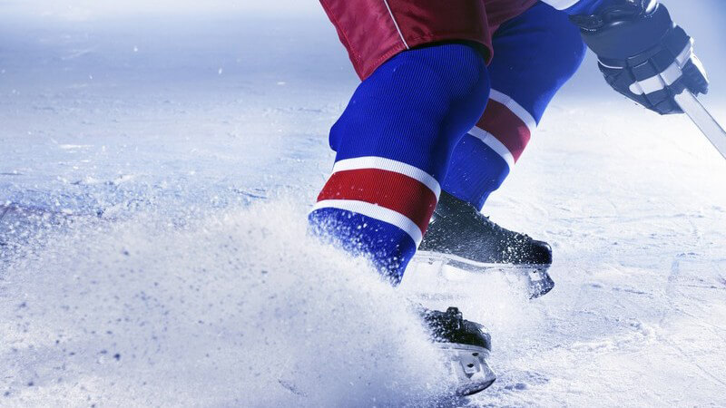 Schlittschuhe eines Eishockeyspielers bremsen auf dem Eis