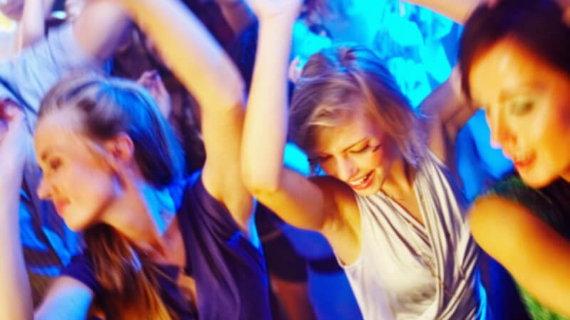 Junge Frauen tanzen in der Disco, blaues Licht, von oben fotografiert