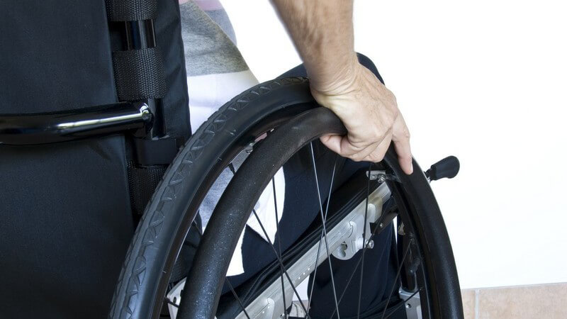 Rückansicht Hand einer älteren Person, die im Rollstuhl sitzt