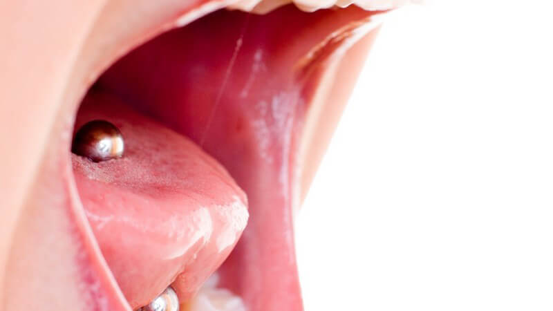 Nahaufnahme schreiender Frauenmund mit Zungenpiercing