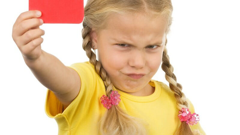 Kleines Mädchen zeigt verärgert rote Karte in Kamera