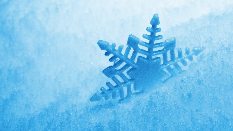Grafik blaue Schneeflocke im Schnee