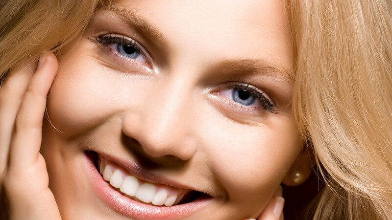 Gesichtsportrait einer jungen blonden lächelnden Frau