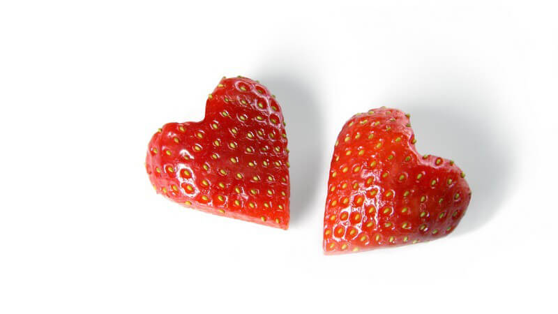 Zwei Erdbeeren in Form von Herzen auf weißem Hintergrund