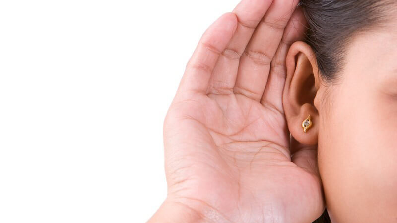 Ohr einer Frau, die ihre Hand unterstützend um das Ohr legt