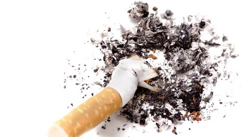 Ausgedrückte Zigarette mit Asche auf weißem Hintergrund