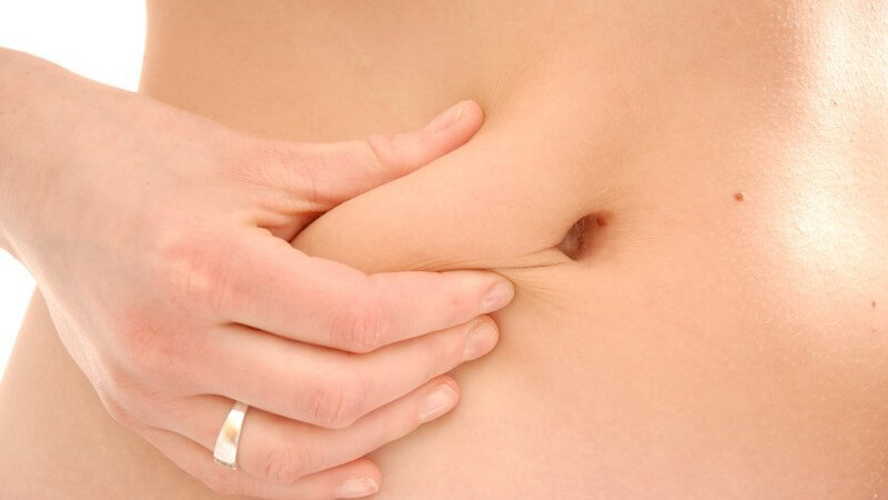 Nahaufnahme Frauen kneift sich in den nackten Bauch