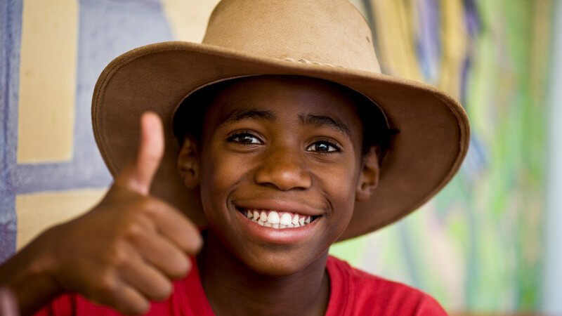 Lächelnder afrikanischer Junge hält Daumen hoch