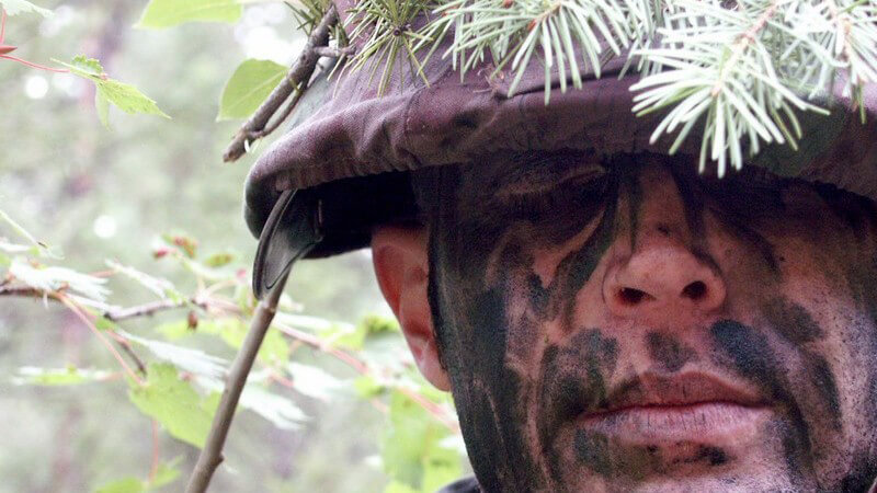 Gesicht eines Soldates, mit Helm und Tarnfarben