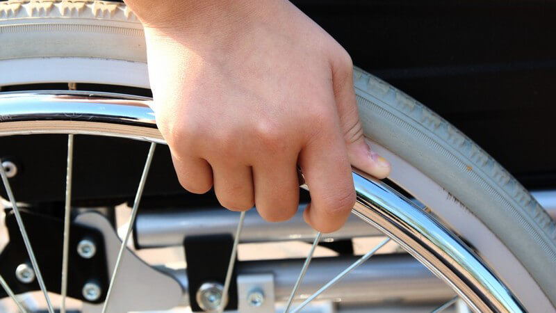 Nahaufnahme Hand am Rollstuhl