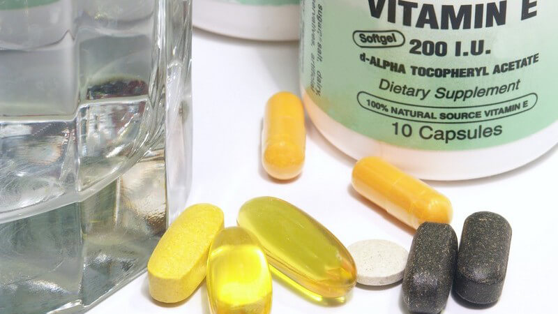 Nahaufnahme Pillen, Vitamindosen, Glas mit Wasser