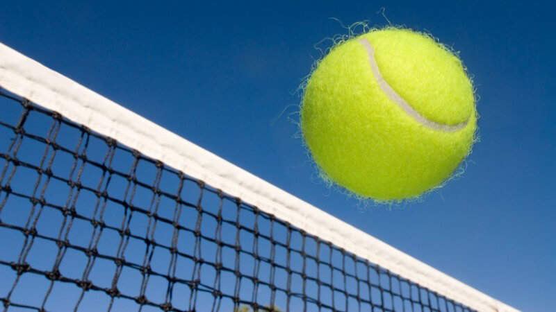 Nahaufnahme Tennisball fliegt übers Netz