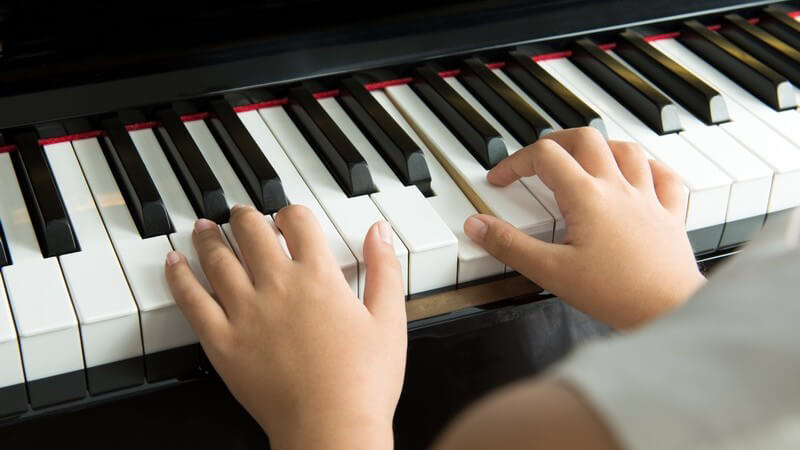Kinderhände spielen auf einem Piano