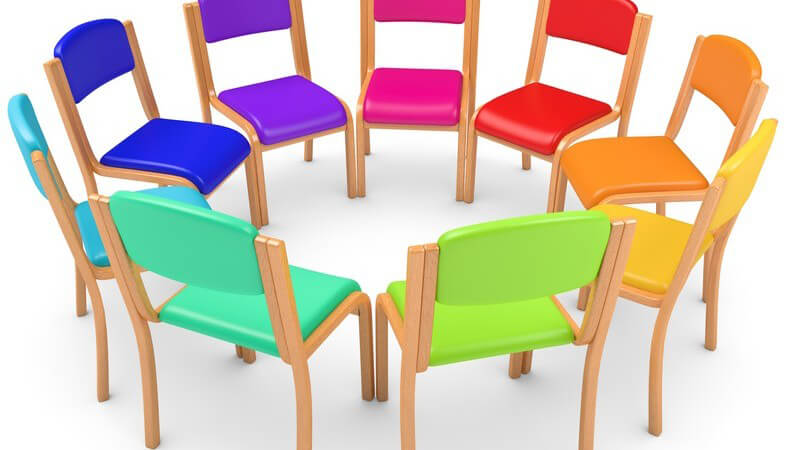 Grafik eines Stuhlkreises aus neun bunten Stühlen