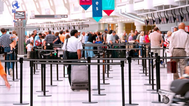 Einsicht in Flughafenhalle mit vielen menschen an Schaltern