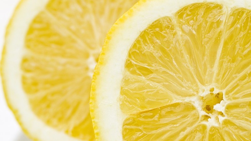 Zwei frische Zitronenscheiben auf weißem Hintergrund